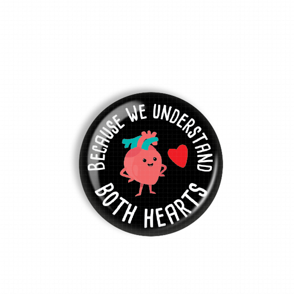 a black button with a pink heart and a blue heart, along with the text "BECAUSE WE UNDERSTAND BOTH HEARTS" written around the edges.