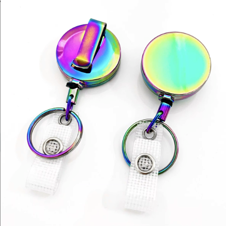 two colorful, rainbow-colored badge holders with metal clasps and rings.