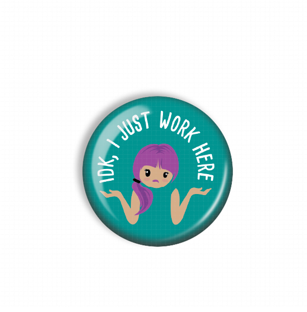 A turquoise button with a cartoon girl and the text "IDK, JUST WORK HERE" printed on it.