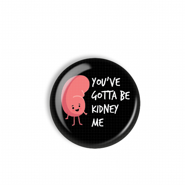 A black button with a pink kidney character and the text "You've gotcha be kidney me" printed on it.