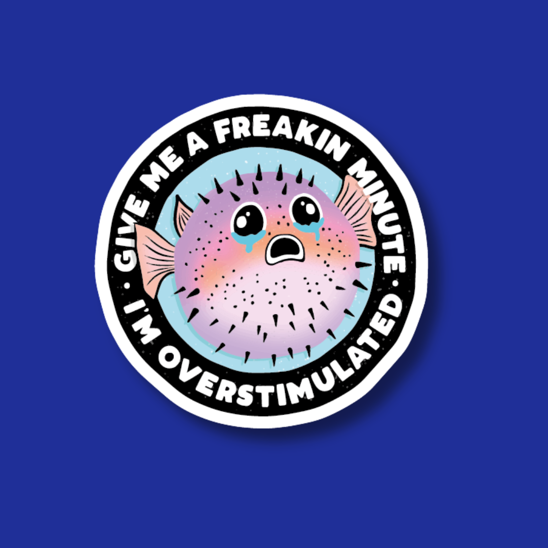 A sticker with a pufferfish and the text "Give me a freakin minute. I'm overstimulated" on a blue background.