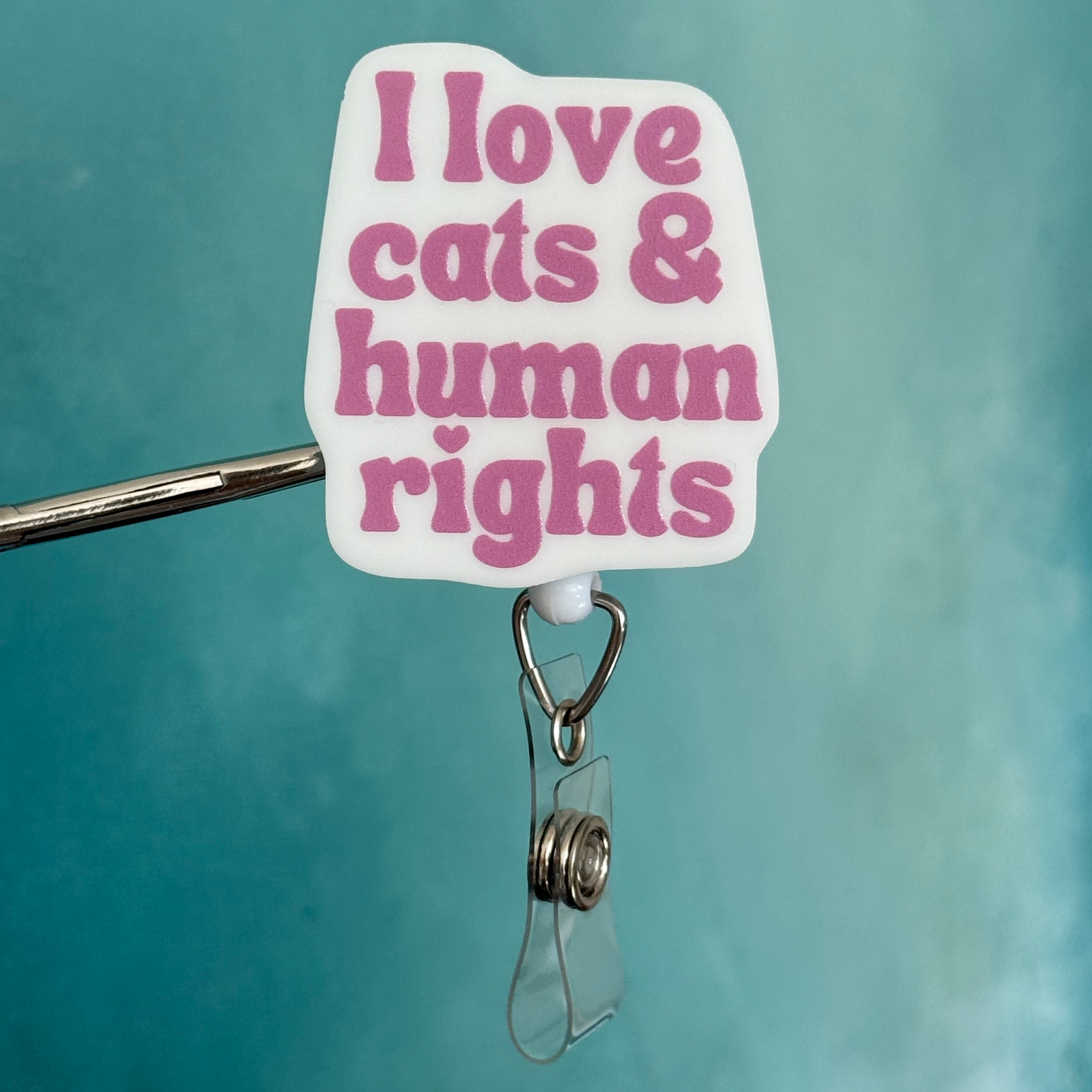 Badge holder with 'I love cats & human rights' text on a teal background