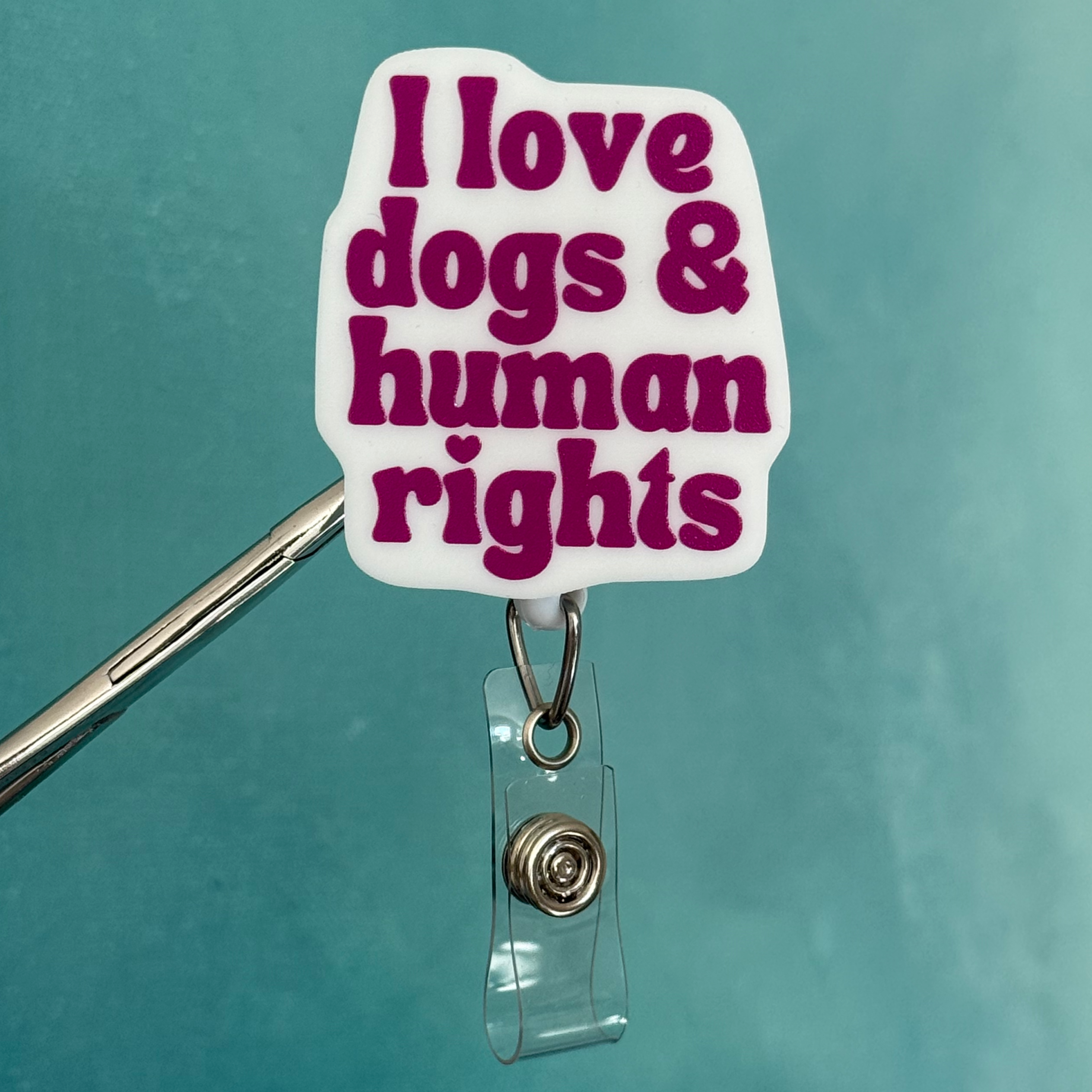 Badge holder with 'I love dogs & human rights' text on a teal background