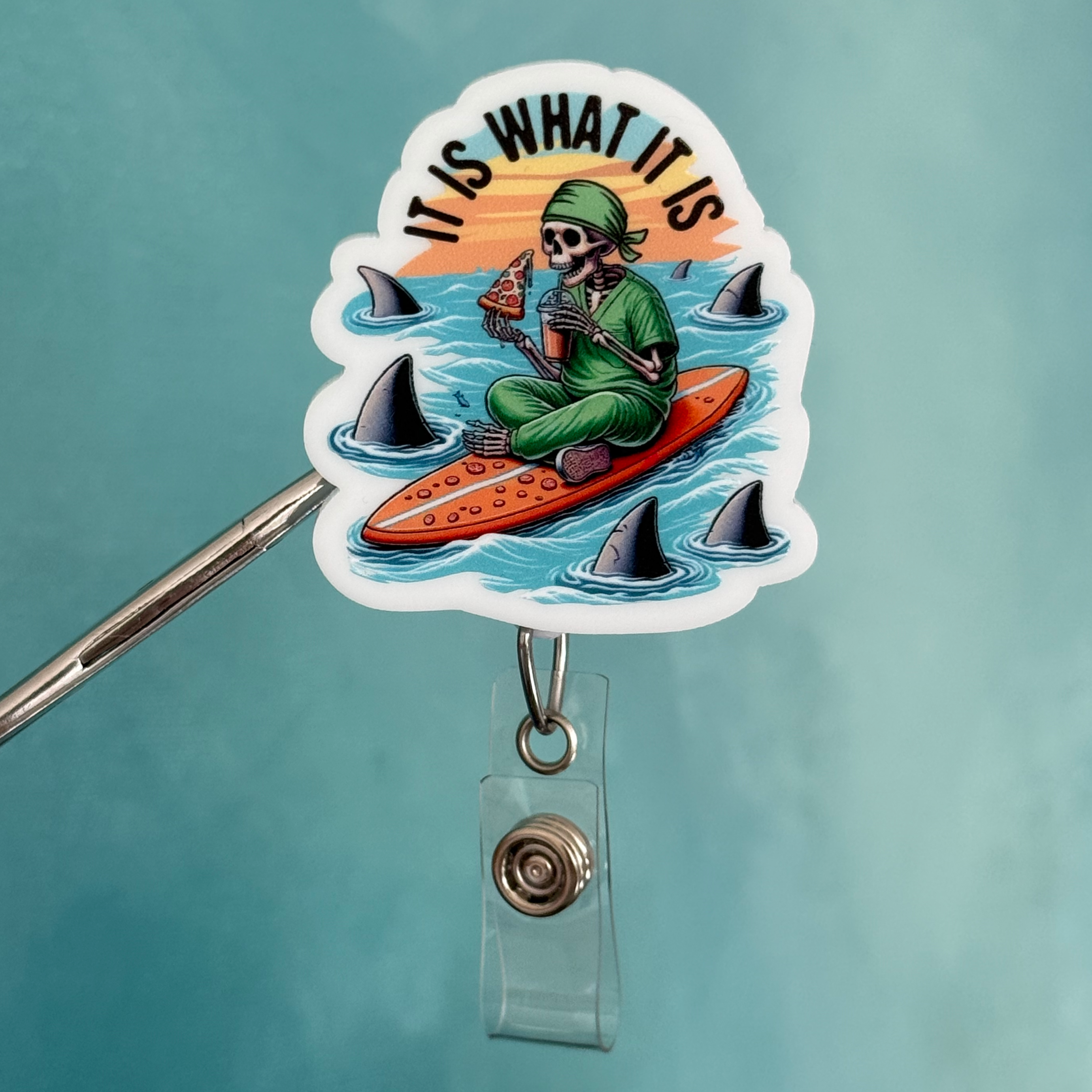 Badge holder with a sticker of a person surfing and text 'IT IS WHAT IT IS' on a blue background