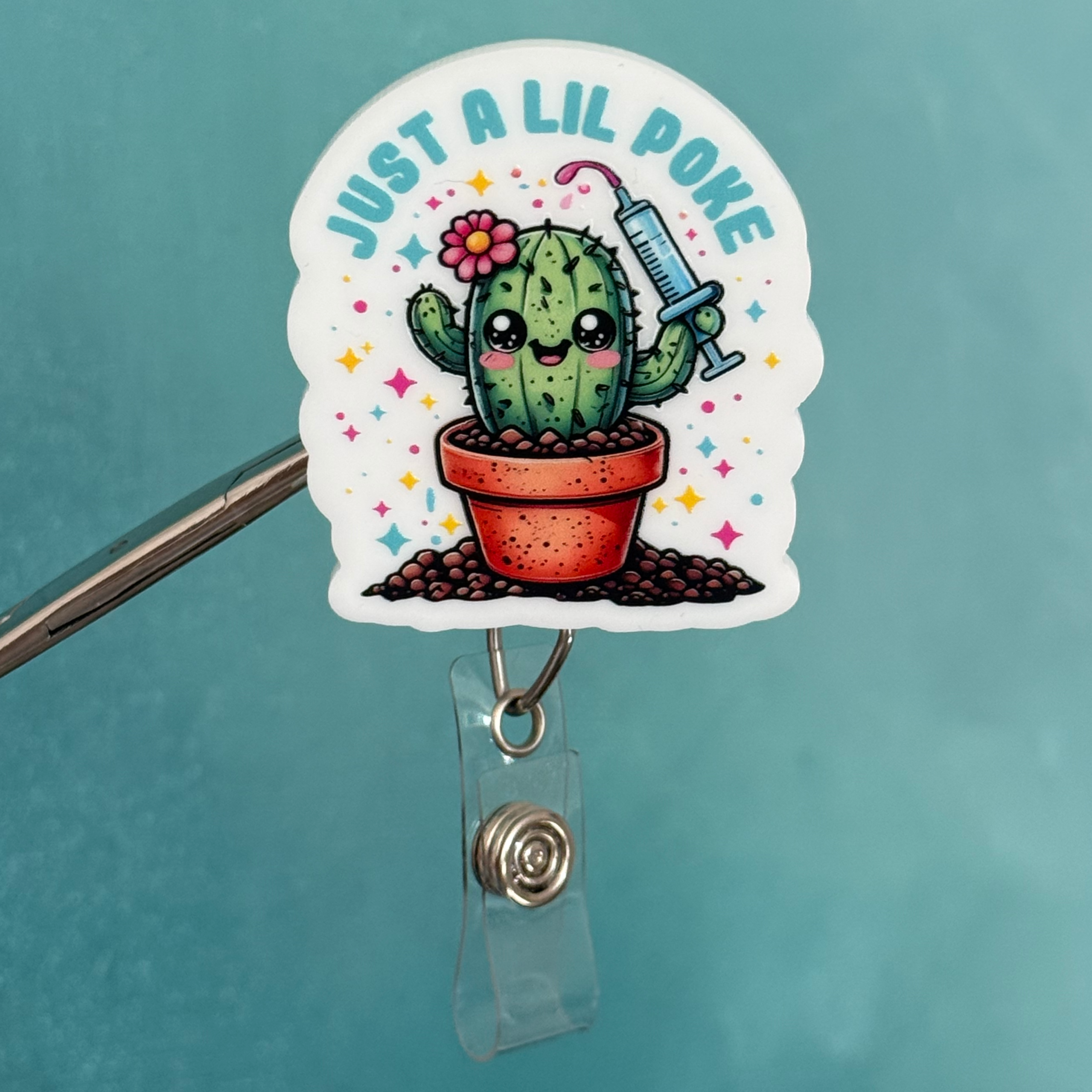Badge holder with a cactus design and text 'Just a lil poke' on a teal background