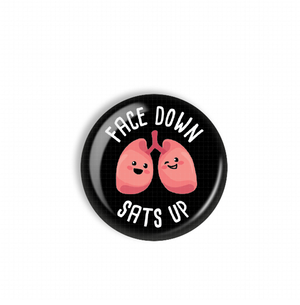 A black button with a cartoon image of a lung and the text "FACE DOWN SAT'S UP" printed on it.